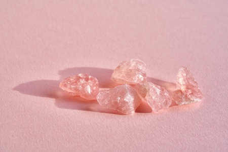 Rose quartz crystals on a pink background with copy space