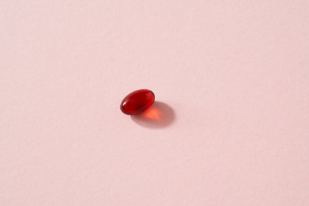 Krill oil pill or softgel on pastel pink background with copy space - nutritional supplement rich in omega-3の写真素材