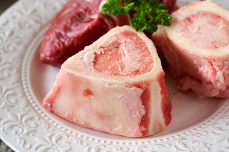 Closeup of fresh beef marrow bones on a plate - ingredient for broth or soupの写真素材