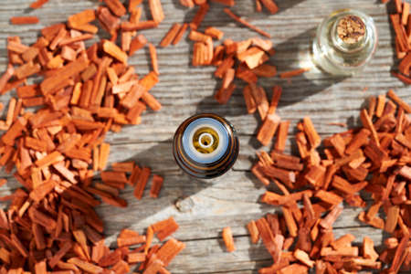 A dropper bottle of aromatherapy essential oil with red sandalwood chips, top viewの写真素材