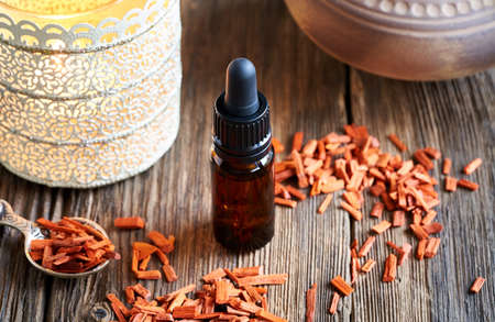 A dark bottle of aromatherapy essential oil with red sandalwoodの写真素材