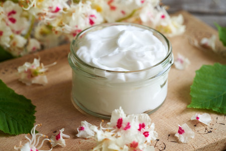 A glass jar of ointment made from horse chestnut blossoms. Herbal medicine.の写真素材