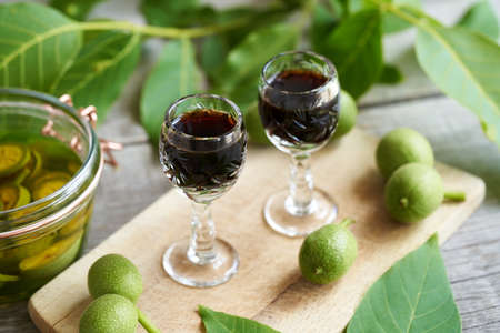 Nut liqueur made from unripe walnuts on a wooden table