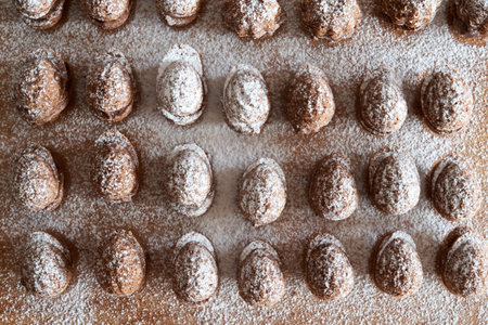 Homemade Christmas cookies in the form of nuts dusted with sugar on a table, top view