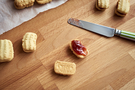 Preparation of traditional Christmas cookies - filling with strawberry marmaladeの写真素材