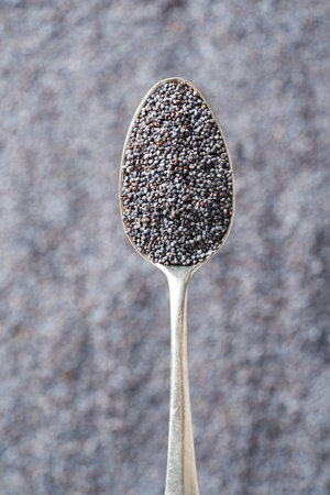 Poppy seeds on a metal spoon, top viewの写真素材