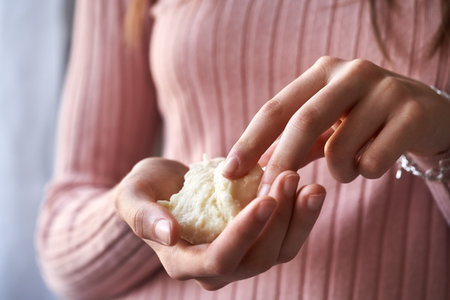 Teenage girl holding a piece of raw unrefined shea butter or karite in her handsの写真素材