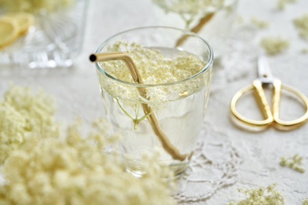 A glass of lemonade with fresh elderberry flowers with golden metal straw. Zero waste eating.の写真素材