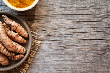 Fresh turmeric root and dried curcuma powder on a wooden rustic background with copy space, top viewの写真素材