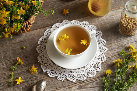 A white cup of herbal tea with fresh St. John'w wort flowersの写真素材