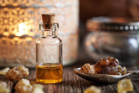 Frankincense essential oil with boswellia resin and a candleの写真素材