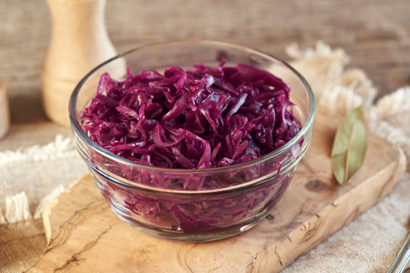 Homemade purple fermented cabbage or sauerkraut in a glass bowl on a tableの写真素材