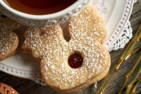 Chicken shaped homemade Linzer Easter cookie near a cup of tea