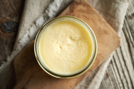 Ghee or clarified butter on a glass jar, top view