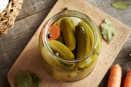 Homemade pickled cucumbers or gherkins in a glass jar on a table, top viewの写真素材