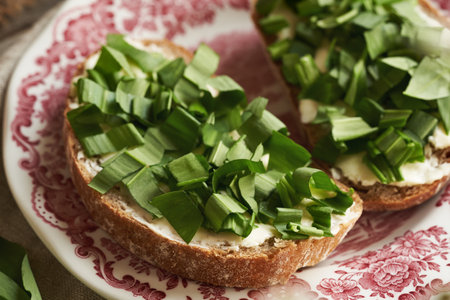 Fresh wild garlic or ramson leaves on a slice of bread with butter
