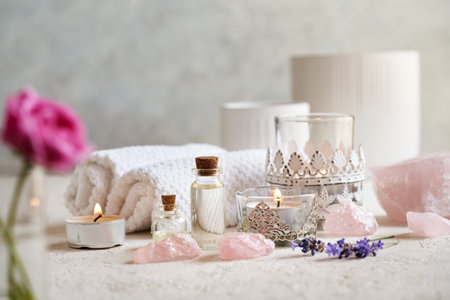 Spa settings with bottles of aromatherapy essential oil, rose quartz stones and lavender and rose...