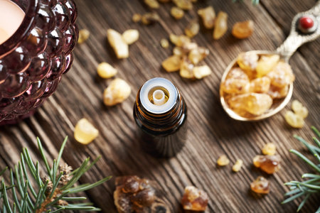 Frankincense essential oil in a dark dropper bottle on a wooden tableの写真素材