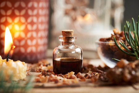 Myrrh essential oil and resin with candles in the backgroundの写真素材