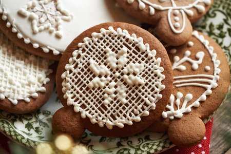 Closeup of homemade gingerbread Christmas cookies decorated with white icing on a green plateの写真素材