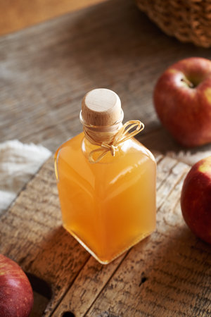 A bottle of apple cider vinegar on a wooden table