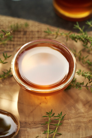 A bowl of thyme syrup on a wooden table