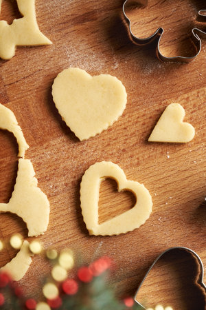 Heart shapes cut out from rolled out pastry dough to prepare traditional homemade Linzer Christmas cookies, top viewの写真素材