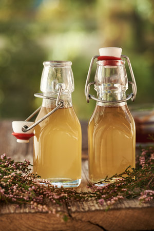 Heather flower syrup in two glass bottles outdoorsの写真素材