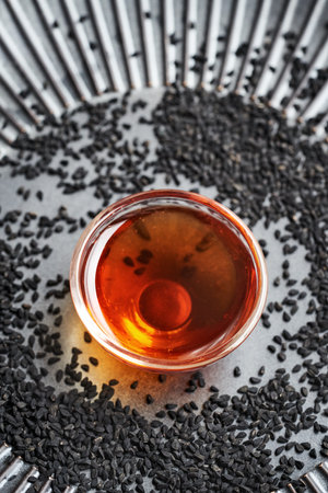 Black cumin or Nigella seed oil in a glass bowl. Healthy anti-inflammatory and antioxidant supplement.の写真素材