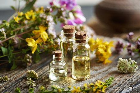Several bottles of aromatherapy essential oil with colorful summer flowersの写真素材
