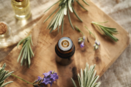 A dark bottle of aromatherapy essential oil with fresh lavender flowers and leavesの写真素材