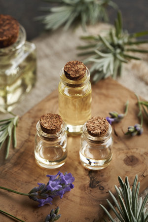 Three bottles of aromatherapy essential oil with fresh blooming lavender plantの写真素材