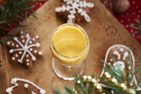 A glass of Eiecognac with gingerbread Christmas cookies on a wooden tableの写真素材