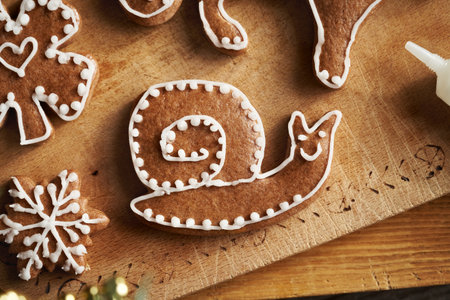 Homemade gingerbread Christmas cookie in the shape of a snail decorated with white icing, top viewの写真素材