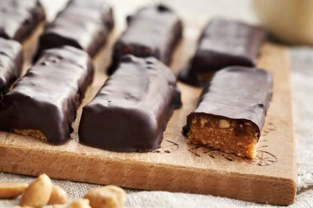 Healthy homemade choocolate bars made of whey protein powder, peanut butter, maple syrup and datesの写真素材
