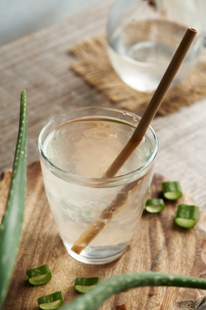 A glass of natural aloe vera juice with fresh leaf with reusable bamboo straw. Zero waste.の写真素材