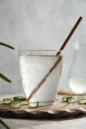 Natural aloe vera juice in a glass cup with fresh leaf with ecological bamboo straw. Zero waste.の写真素材
