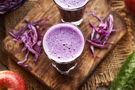 Purple cabbage juice with fresh apples and cucumbers on a tableの写真素材