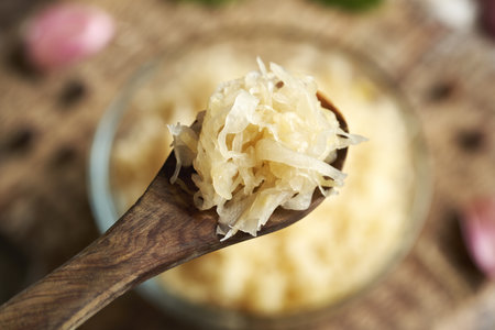 Homemade fermented cabbage or sauerkraut on a wooden spoonの写真素材