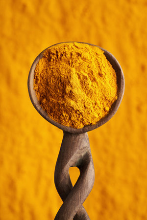 Turmeric root powder on a wooden spoon, top viewの写真素材