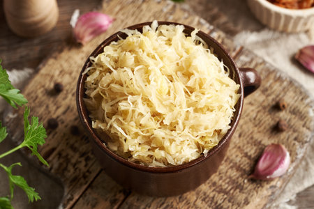 Fermented white cabbage or sauerkraut in a brown pot. Probiotic food.の写真素材