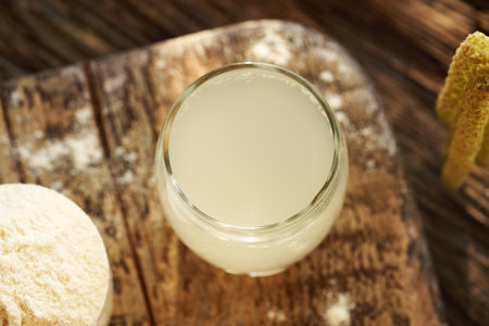 Fresh natural whey in a cup on a table - protein rich healthy nutritional supplement