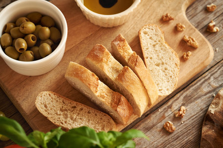 Sliced Italian ciabatta bread, olive oil with balsamic vinega, fresh basil and walnuts