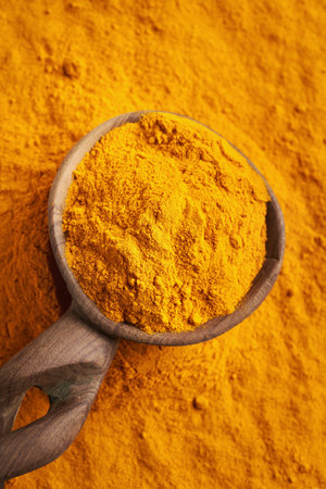 Turmeric powder on a wooden spoonの写真素材