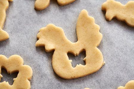 Hen shape cut out from raw pastry dough on parchment paper - preparation of homemade Linzer Easter...