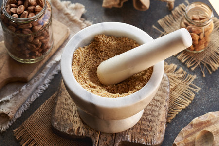 Preparation of homemade hazelnut butter by crushing nuts in a white marble mortarの写真素材