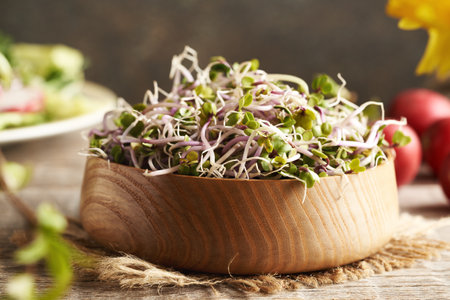Fresh homegrown radish sprouts in a wooden bowl, closeupの写真素材