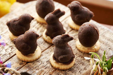 Bunny and chicken shaped homemade Easter cookie filled with eggnog cream, with spring flowersの写真素材