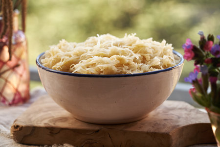 A bowl of fermented cabbage or sauerkraut with spring flowersの写真素材