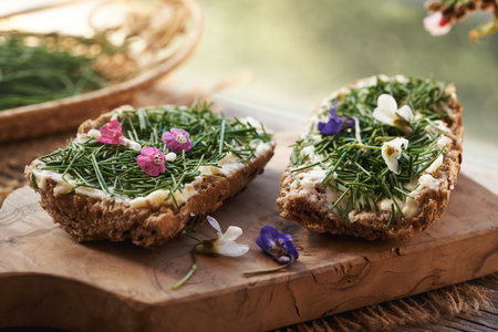 Wild crow garlic or onion grass on slices of bun - wild edible plant harvested in early springの写真素材